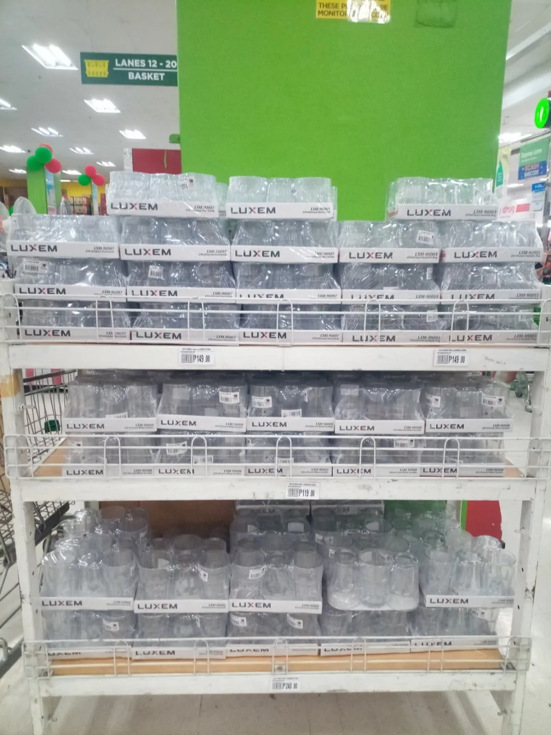 Shelves stocked with packs of Luxem glasses at a Puregold supermarket